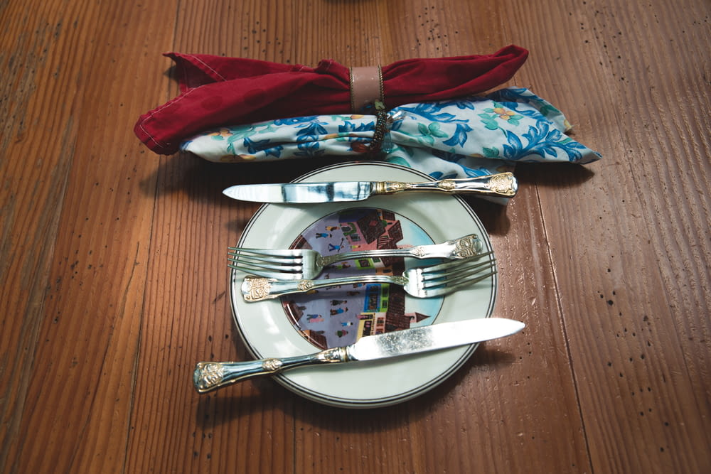 silver flatware set on white plate on tabletop