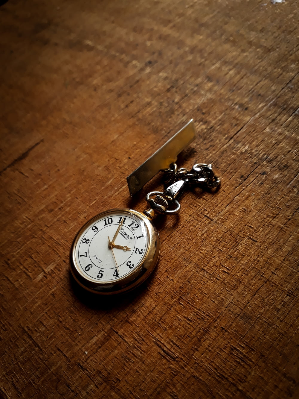 round gold-colored pocketwatch at 2:55