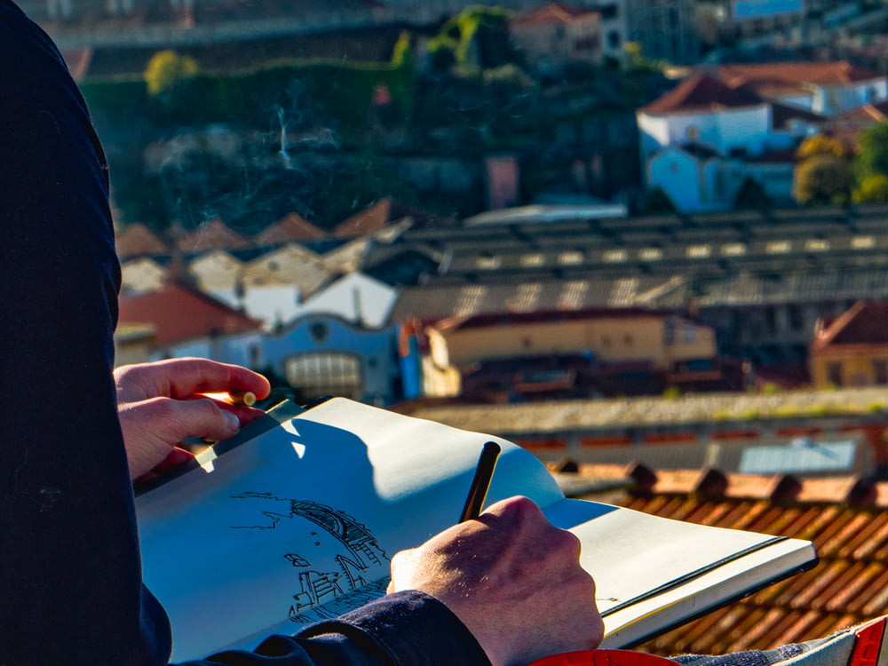 man sketching houses on roof