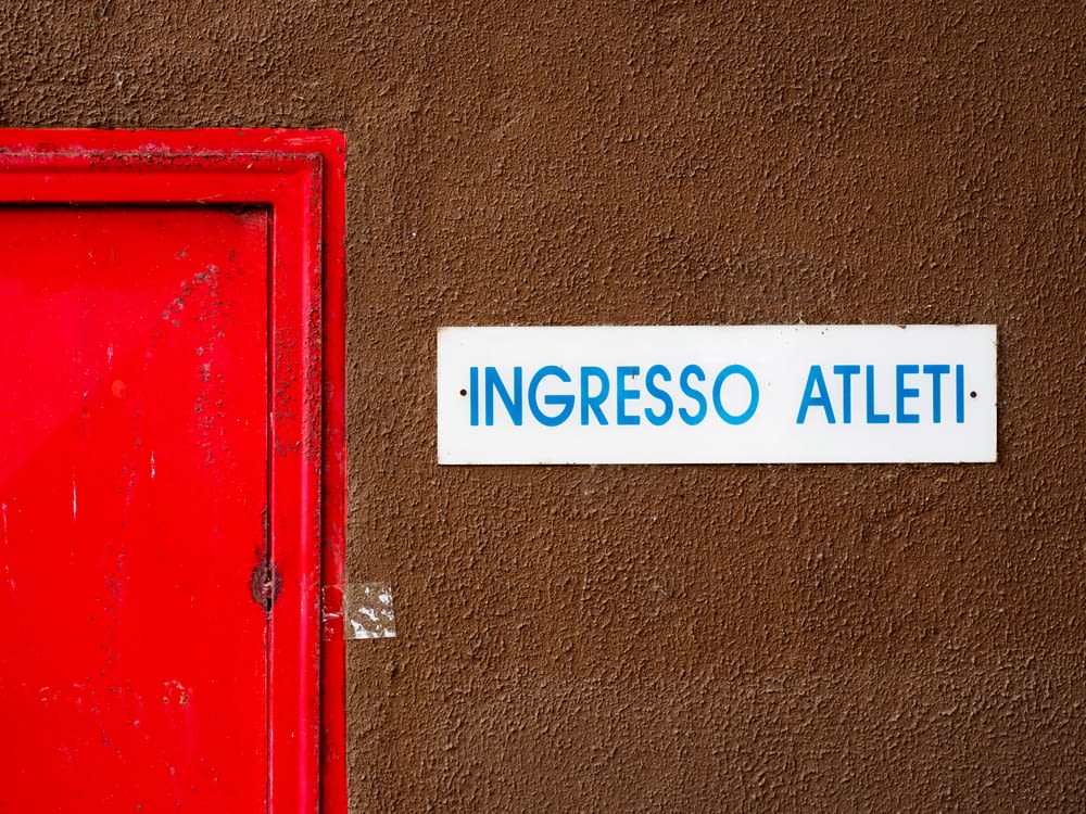 foto em close-up da sinalização do Ingresso Atleti ao lado da porta