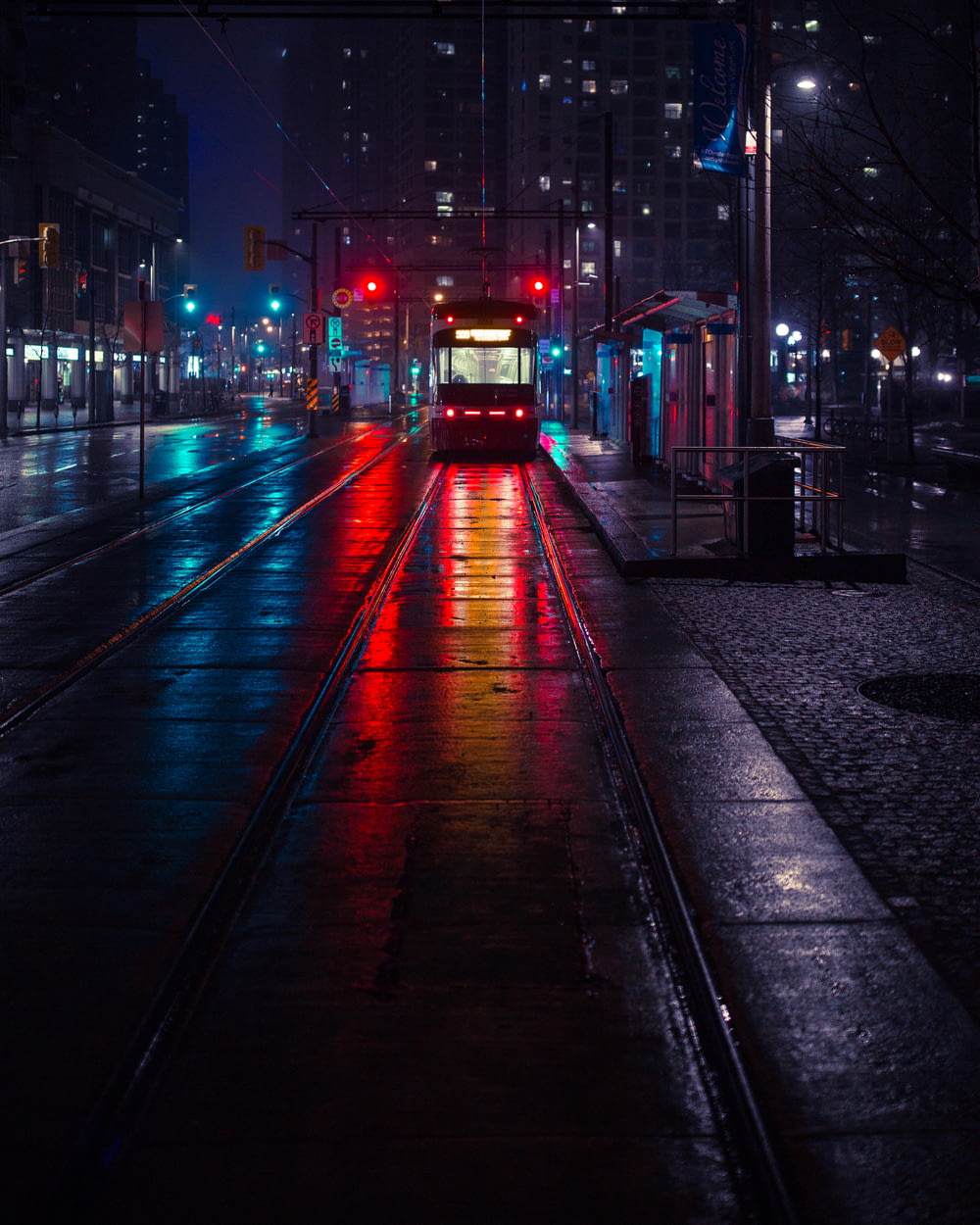 夜間の待合駅横の路面電車の写真