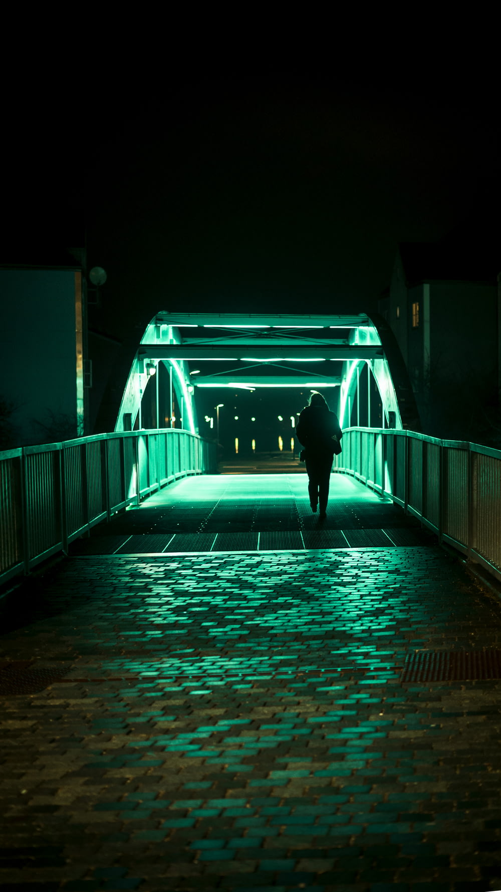 Persona que pasa sola en el puente durante la noche