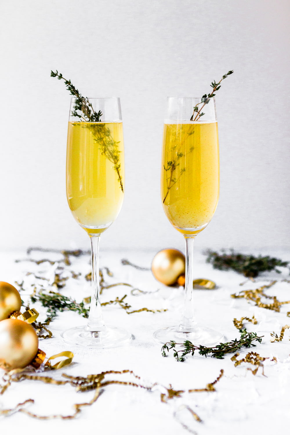 Flache Fokusfotografie von Champagnergläsern, umgeben von goldenen Kugeln