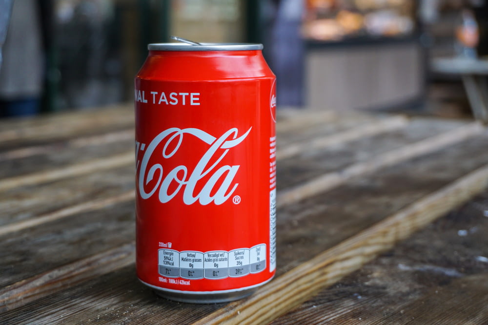 Lata de Coca-Cola na mesa de madeira marrom
