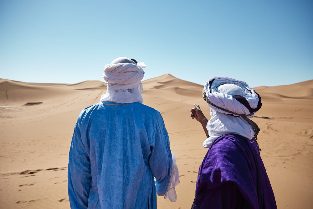 two persons standing on desert