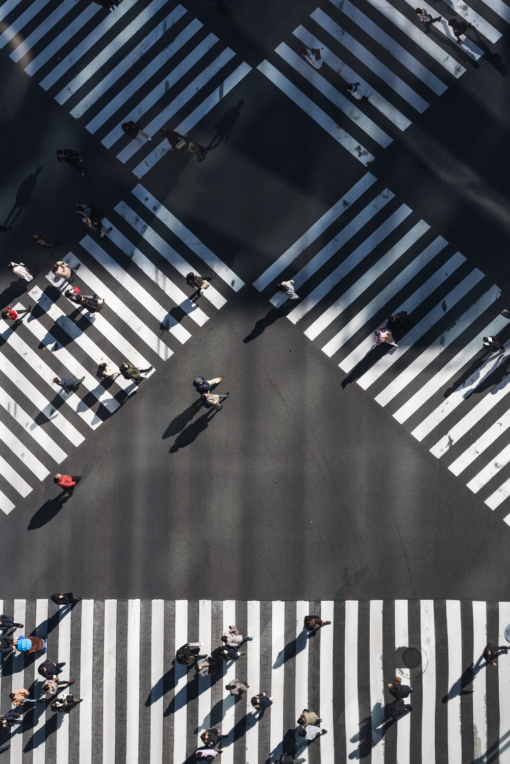 Photographie aérienne de personnes marchant dans la rue de l’intersection pendant la journée
