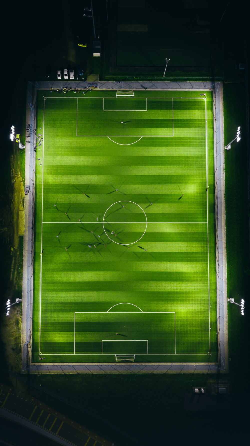 Fotografia a volo d'uccello del campo da calcio verde con le luci