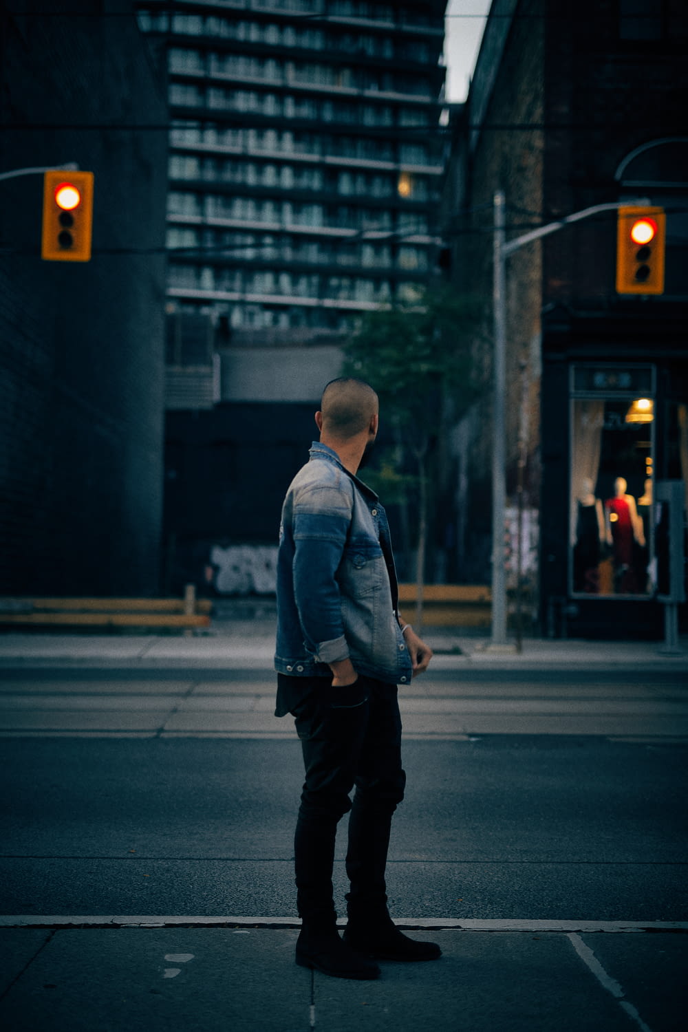 Hombre de pie cerca de un edificio alto y semáforos