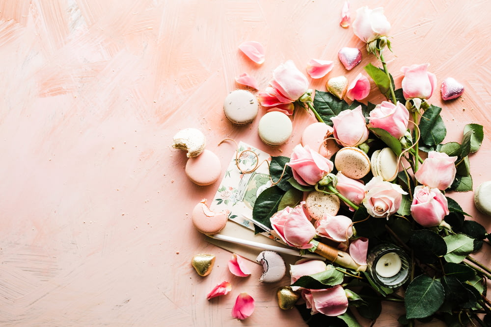 Flatlay-Fotografie von Makronen und rosa Rosenblüten