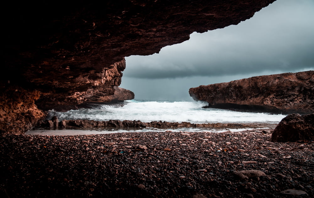 shore under rock formation during cloudy day