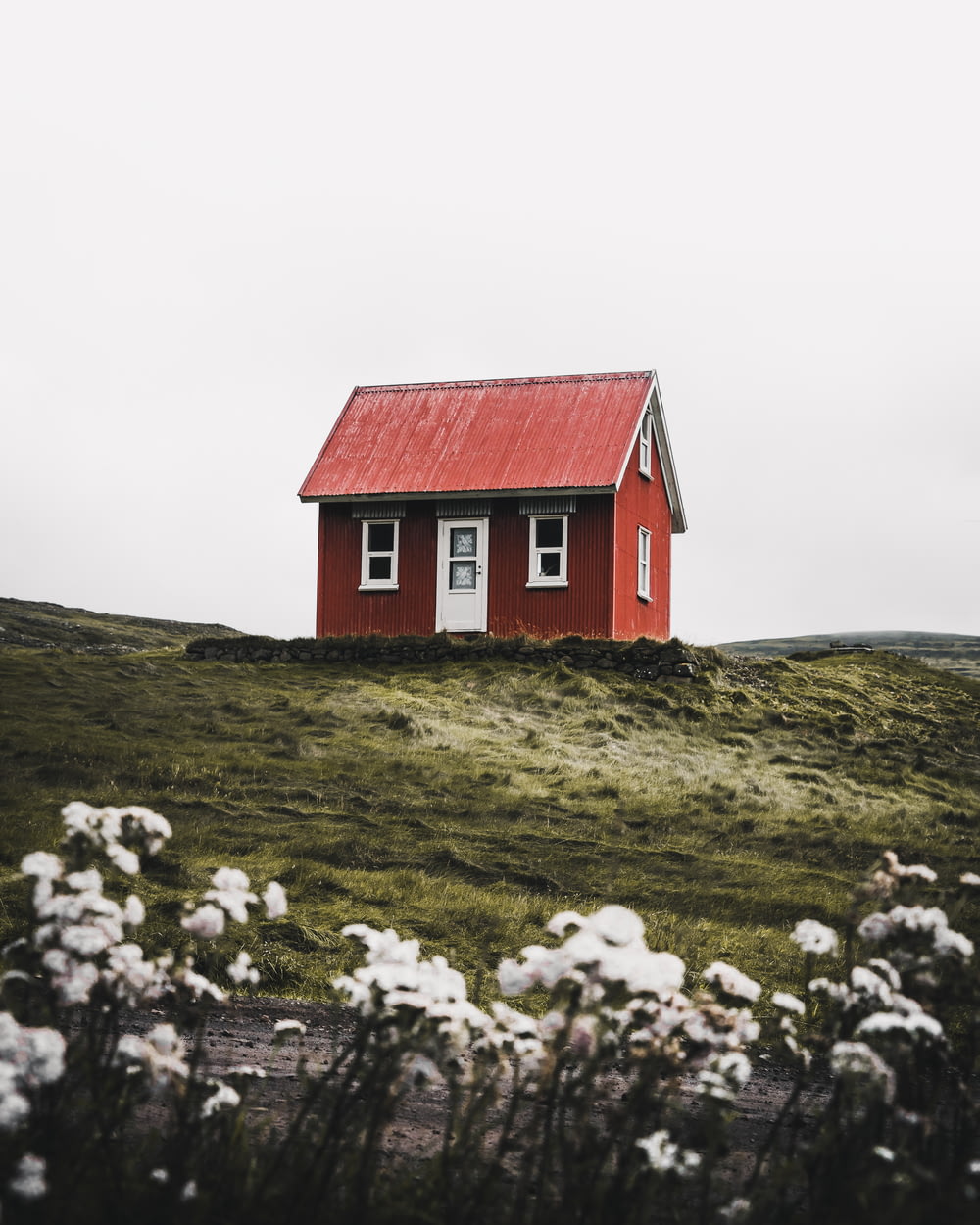 Rotes und weißes Haus umgeben grüne Rasenfläche