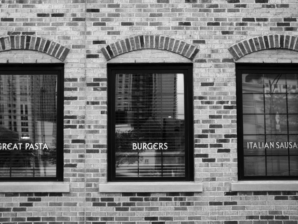 grayscale photography of building with glass windows
