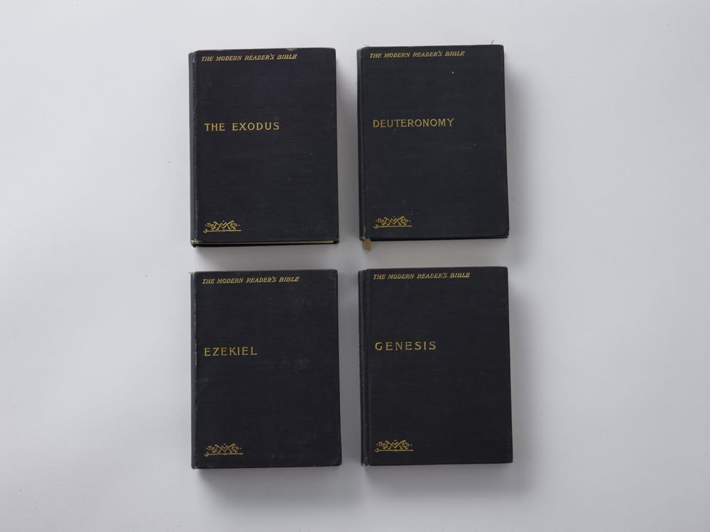 four assorted-title books on white surface