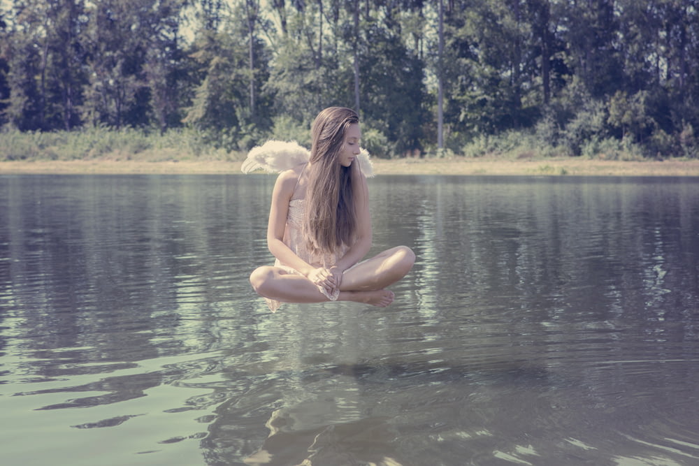 woman floating above body of water