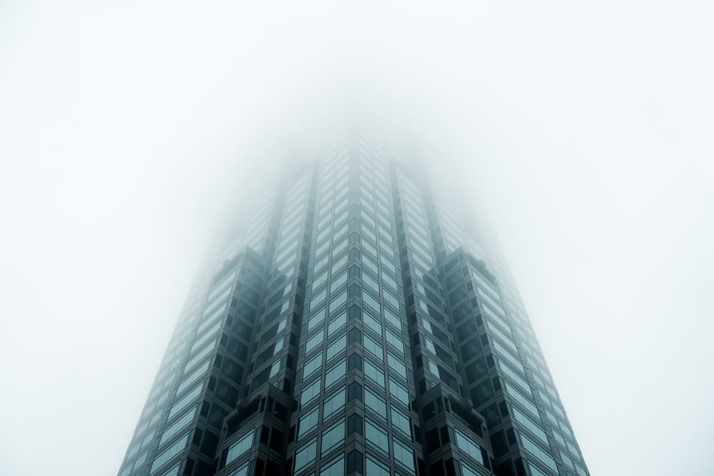 black high-rise building covered with fog