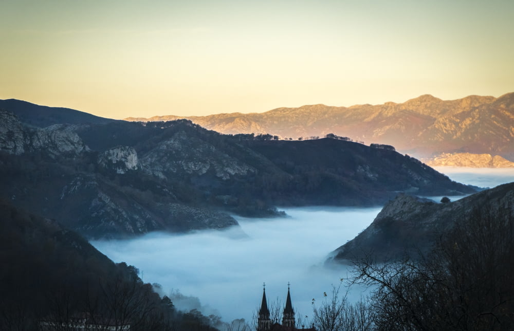 photo de paysage de brouillards entre les montagnes grises pendant la journée