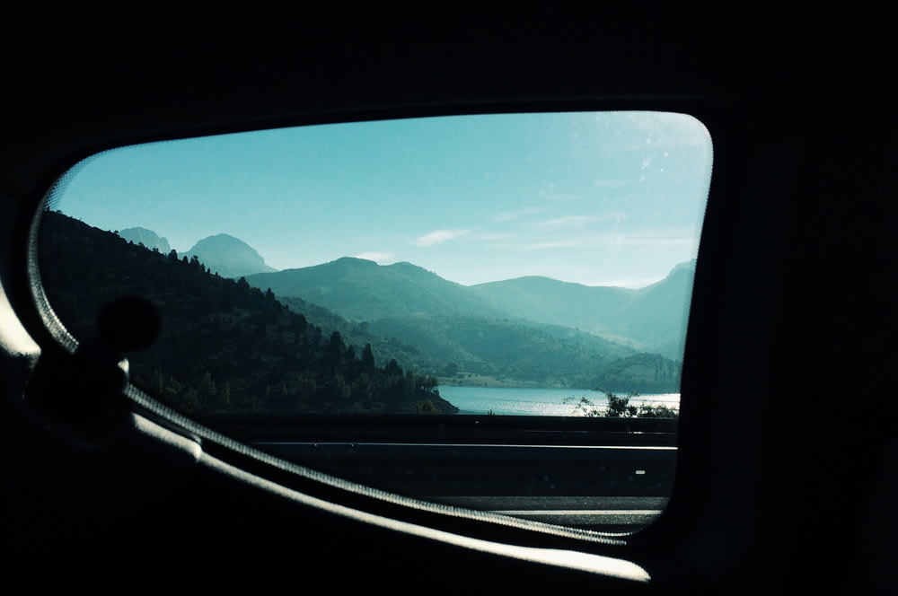 a view from inside a car of mountains and a lake