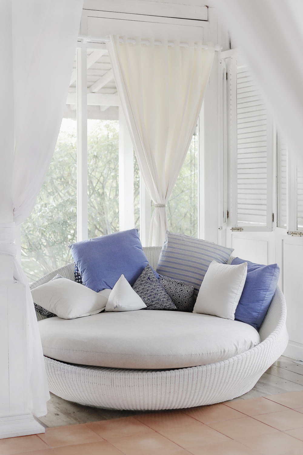 white cuddle chair and throw pillows near window
