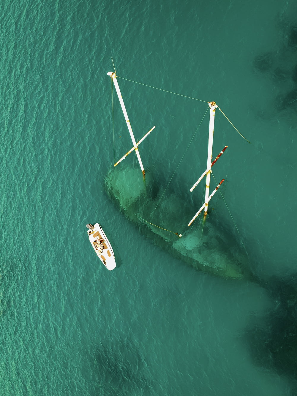 aerial view of green body of water with sank ship