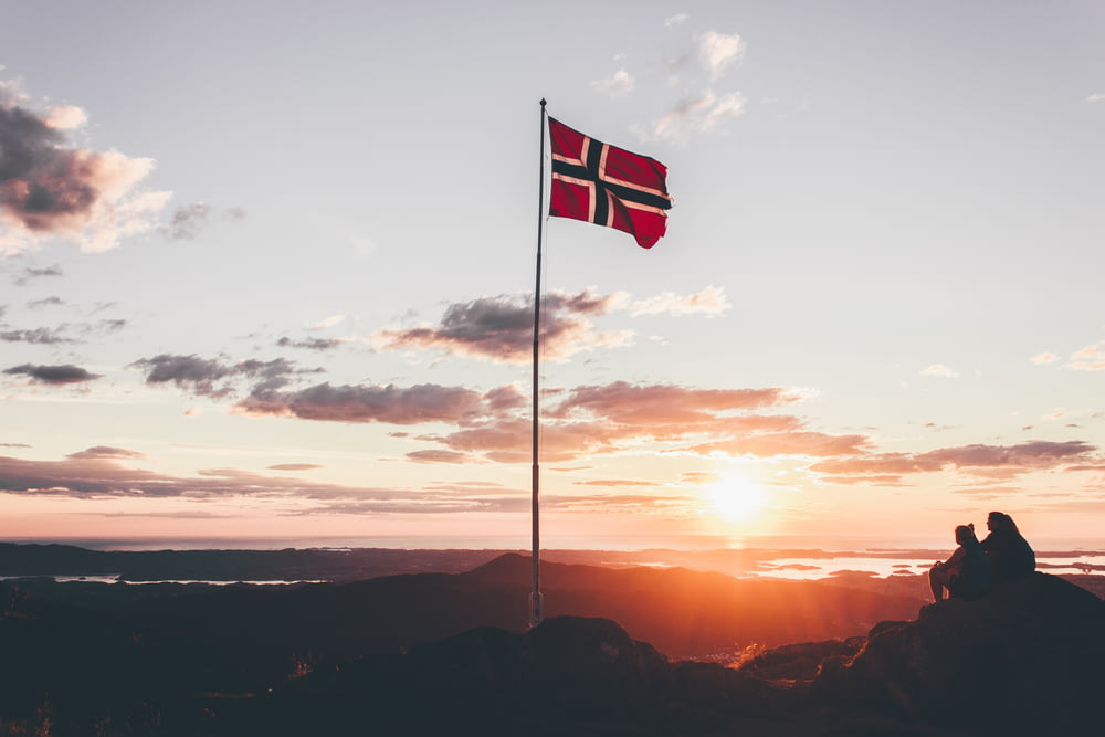 崖の上に立つノルウェーの国旗