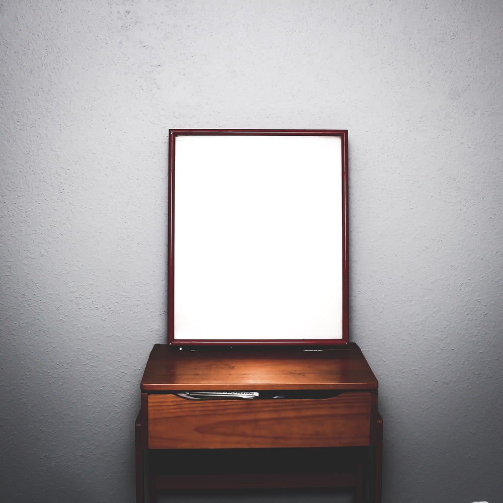 흰색 방 안에 거울이 있는 갈색 나무 서랍장