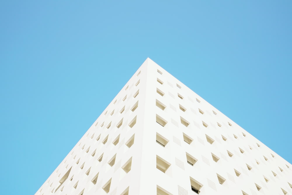 Fotografia di vista dell'occhio del verme dell'edificio bianco sotto il cielo limpido blu durante il giorno