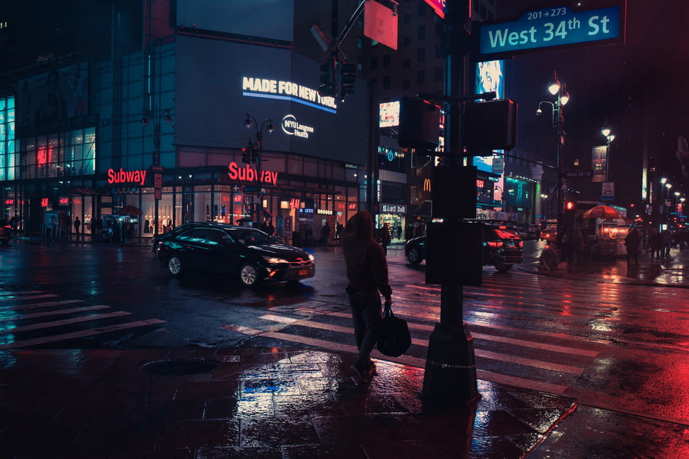 Persona in piedi accanto al semaforo durante la notte