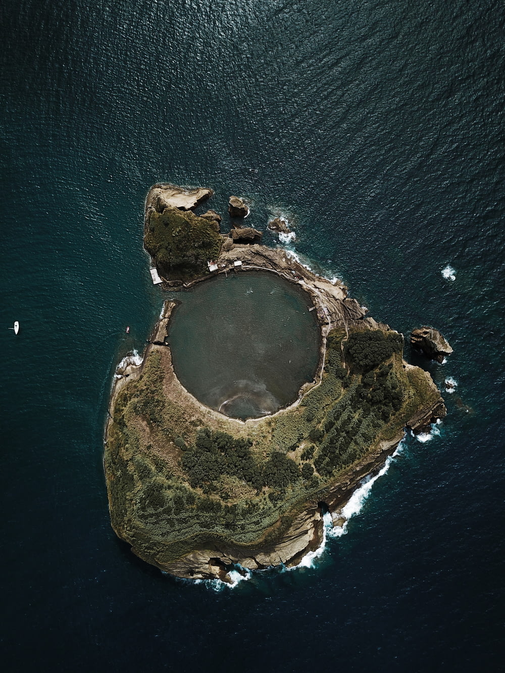 top view photography of island covered with trees surrounded by body of water during daytime