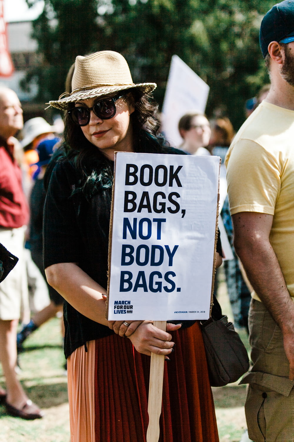 Frau mit Büchertaschen, nicht Leichensäcken. Schild