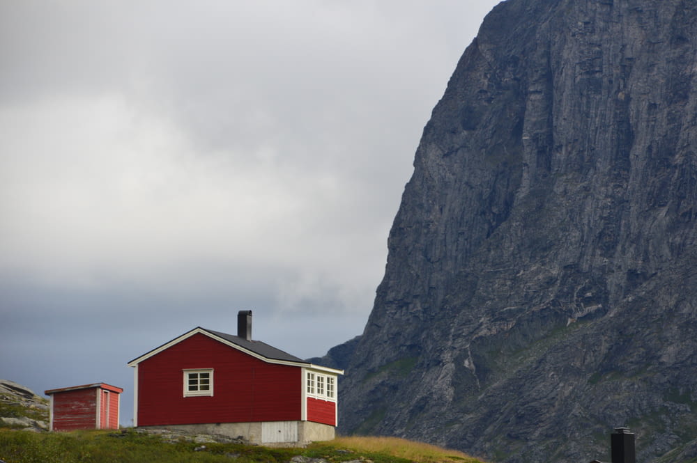 Landschaftsfotografie des roten Hauses mit Blick auf den braunen Berg
