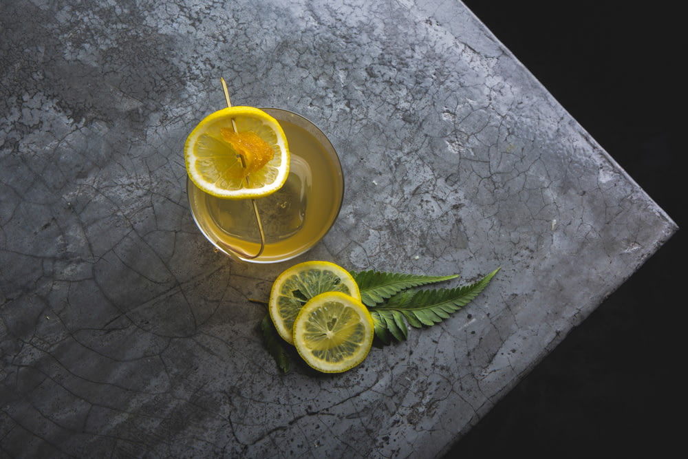 three lemon slice near glass on gray surface
