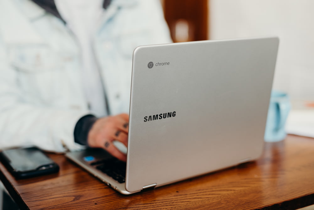 Flachfokusfotografie einer Person mit grauem Samsung-Laptop