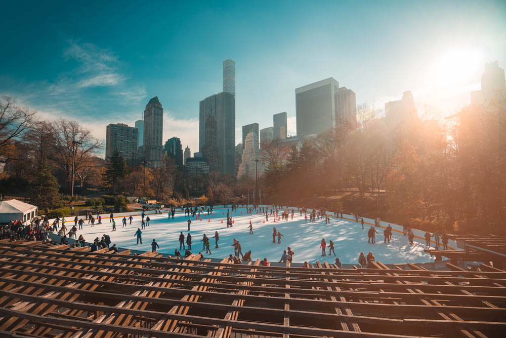 pessoas patinando no gelo no parque durante o dia