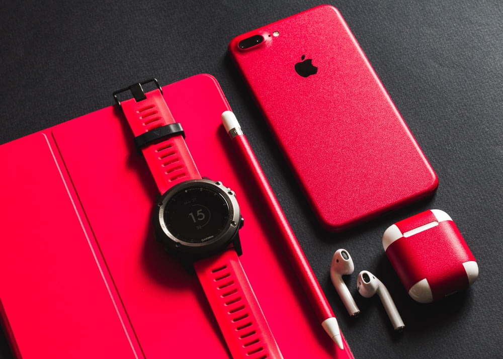 a red apple watch, headphones, and a red case