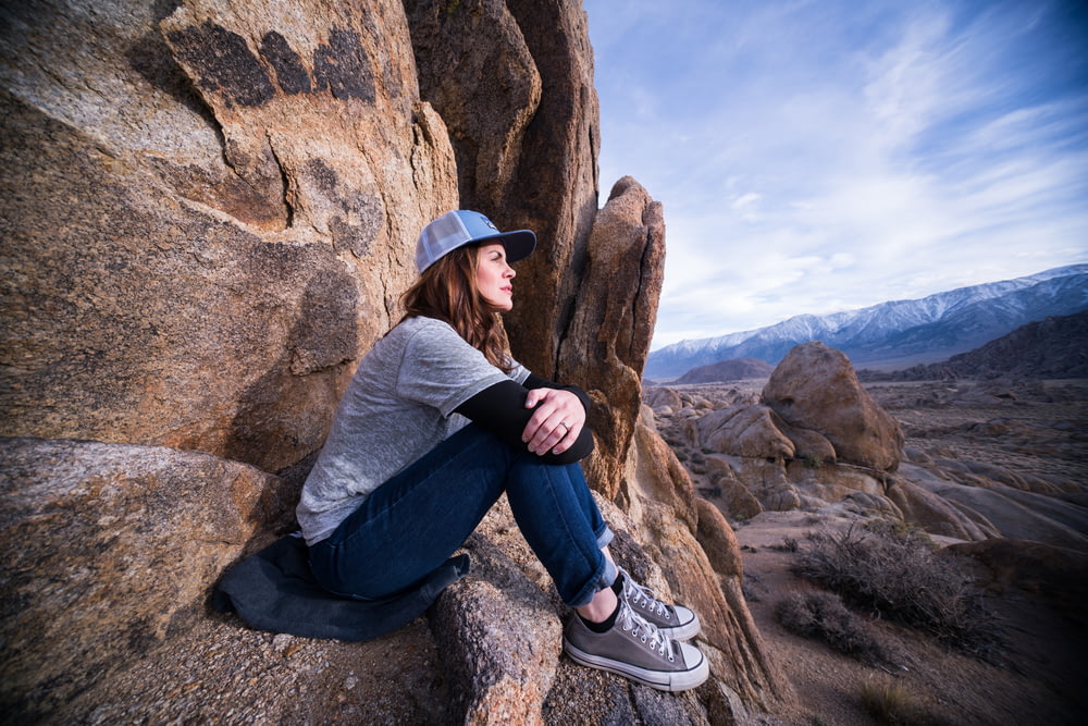 Donna che si siede sulla formazione rocciosa marrone