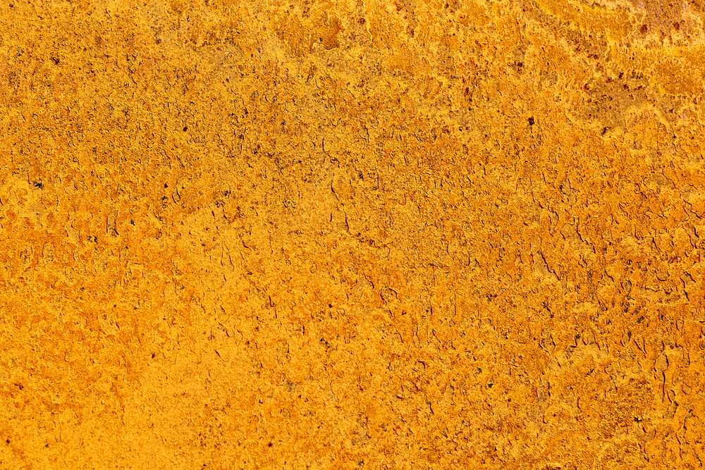 a close up of a yellow surface that looks like dirt