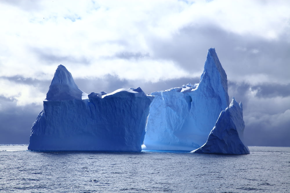 Dos icebergs bajo el cielo nublado durante el día