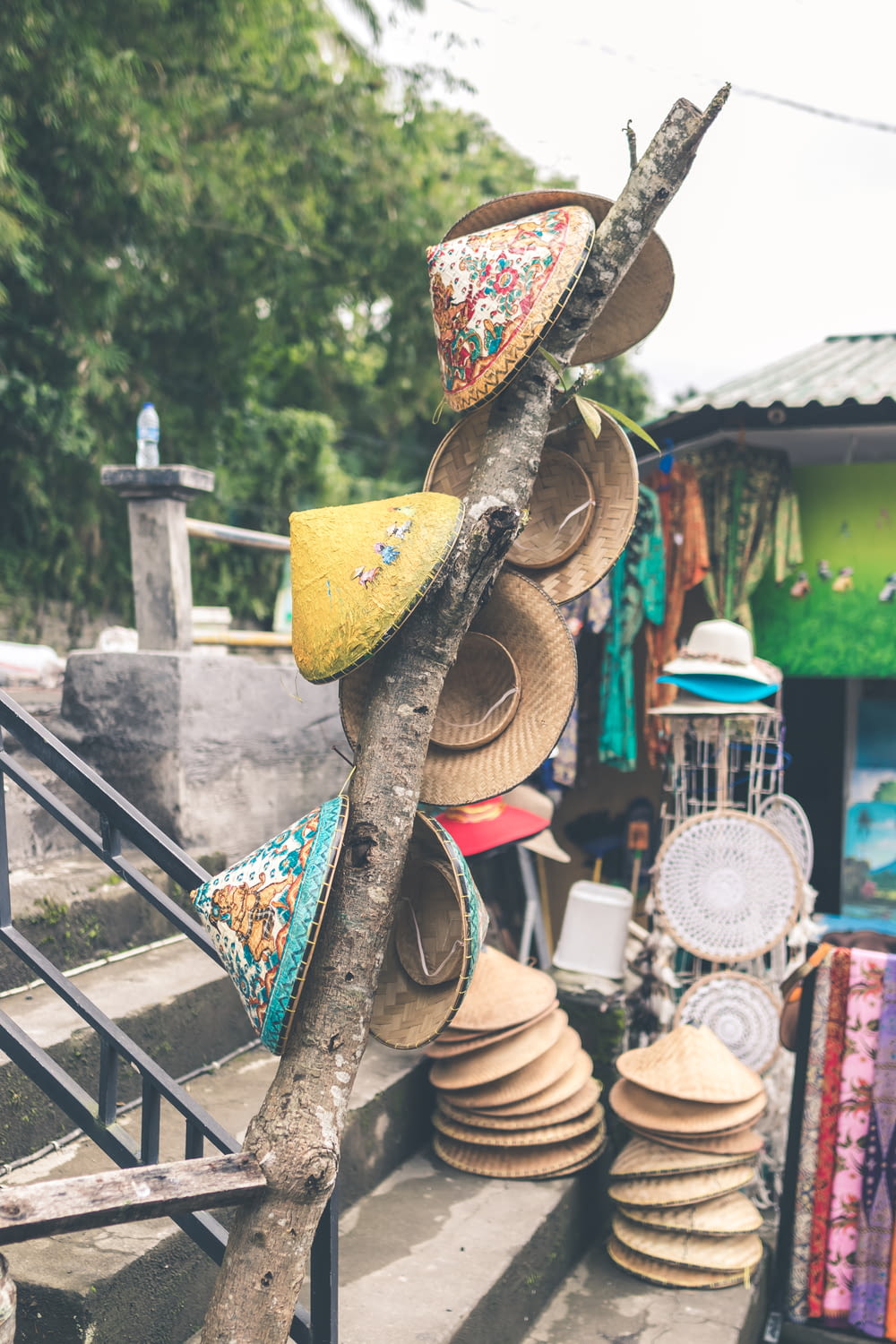 assorted-color straw hats on concrete stair