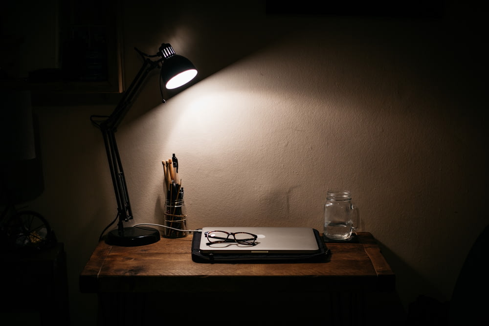 lampe de bureau noire sur table en bois marron
