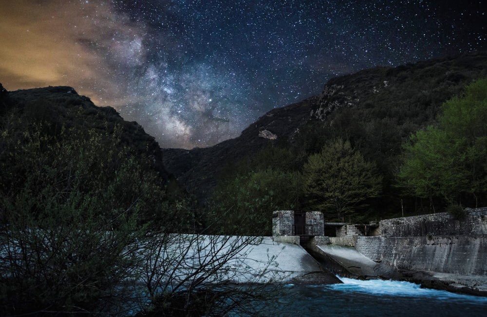 Staudamm in der Nähe des Berges bei Nacht
