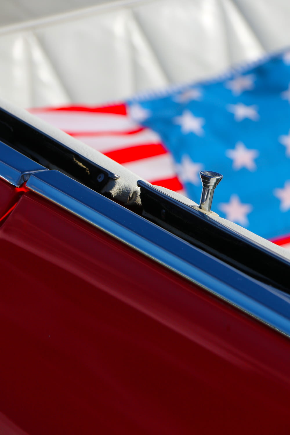 a close up of a red car with an american flag in the background
