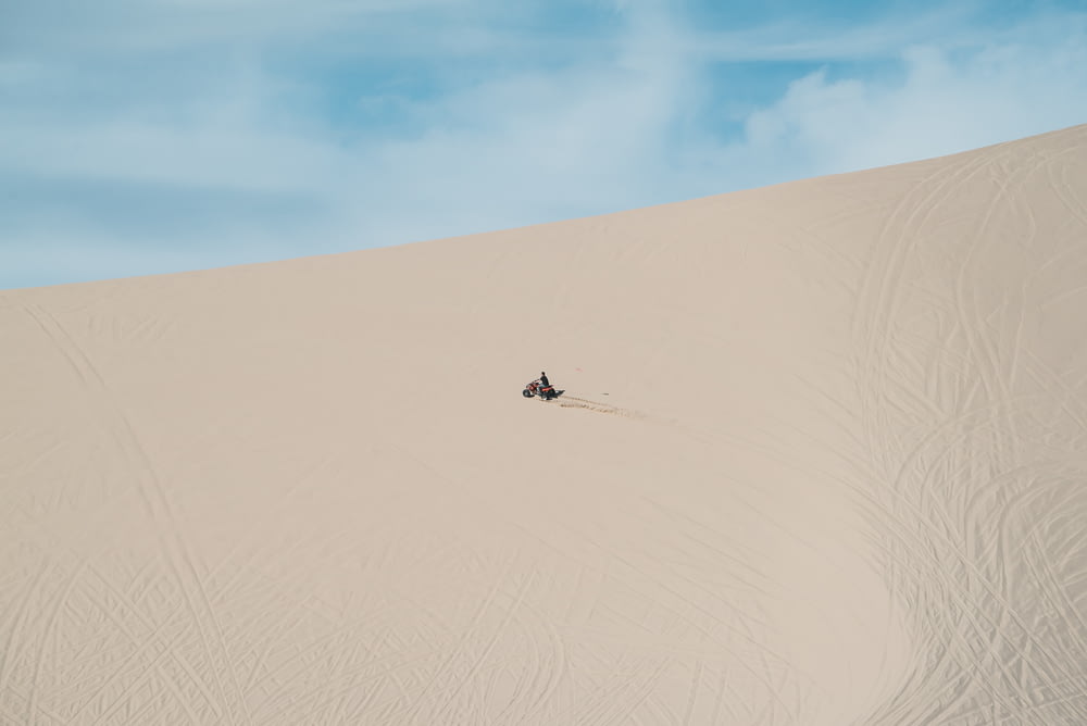 pessoa andando de moto na areia