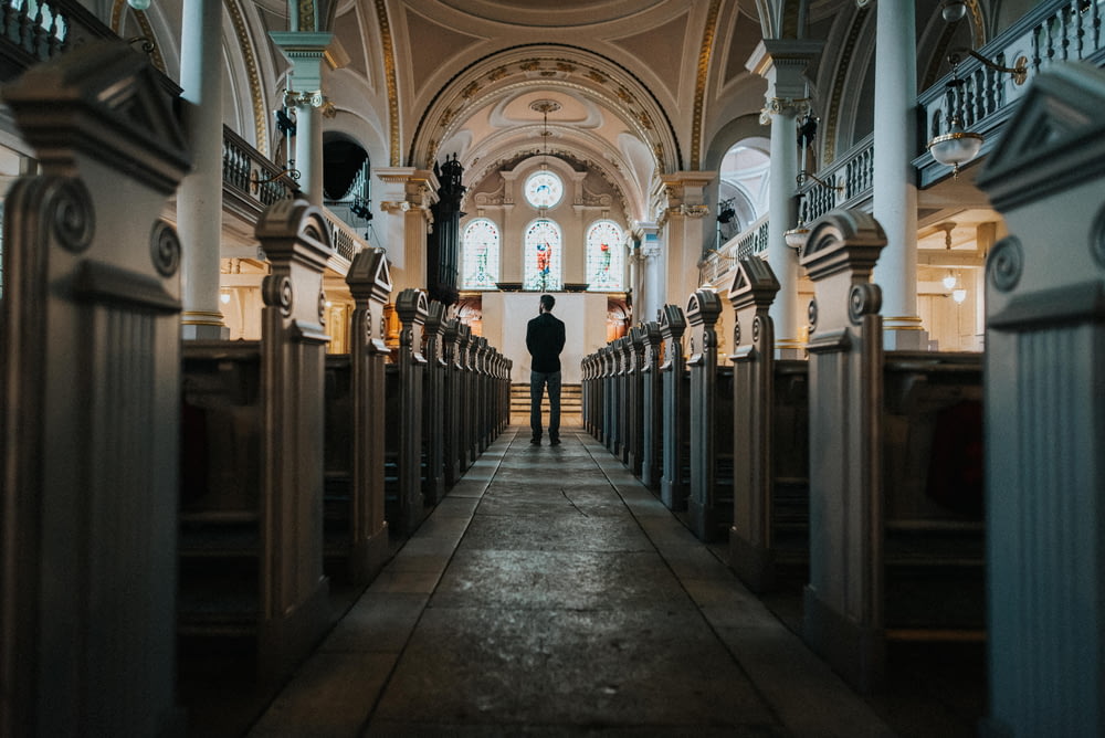 man standing between church pews