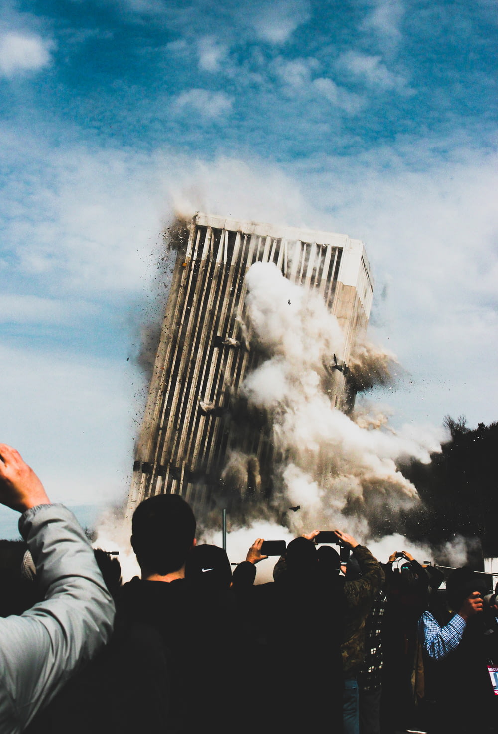 persone che scattano foto di un edificio che crolla