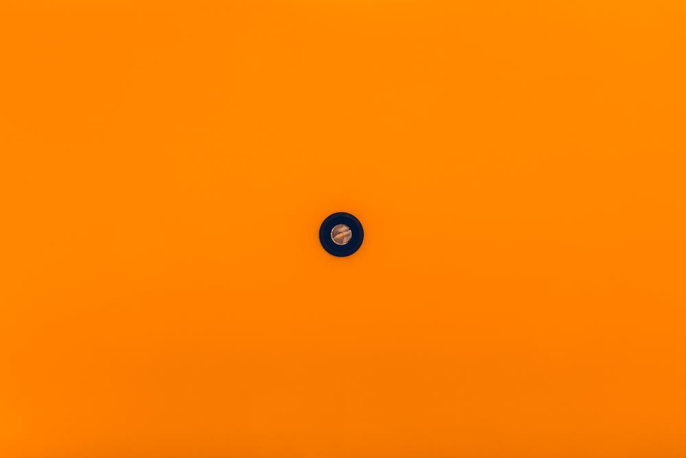 an orange background with a black circle in the center