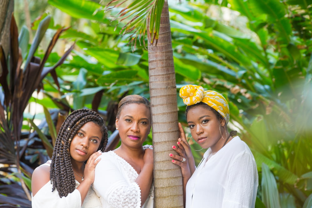 Drei Frauen stehen neben Baum