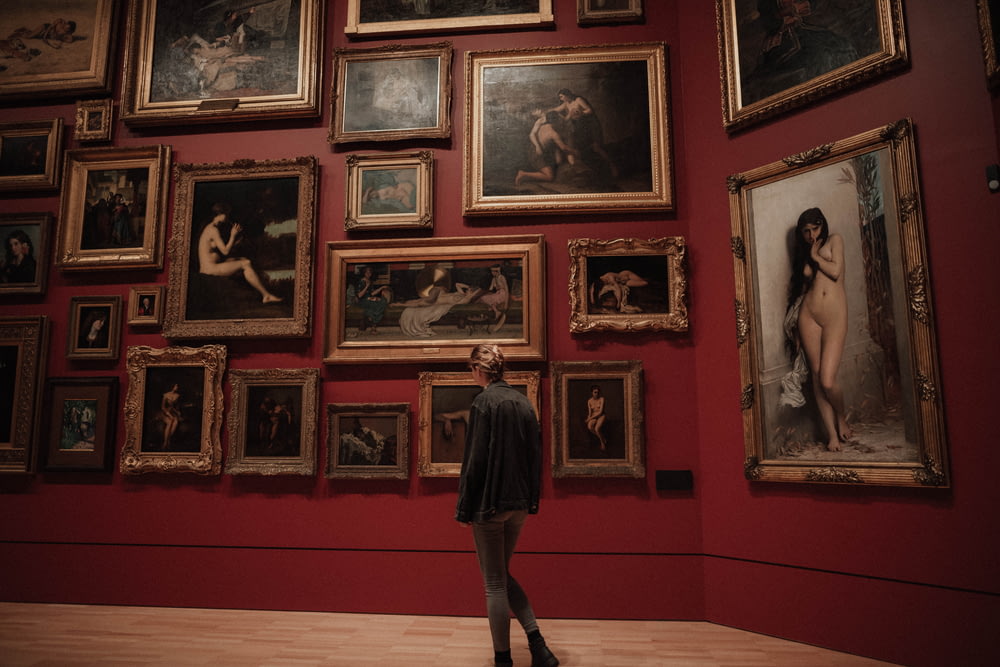 femme debout devant des peintures