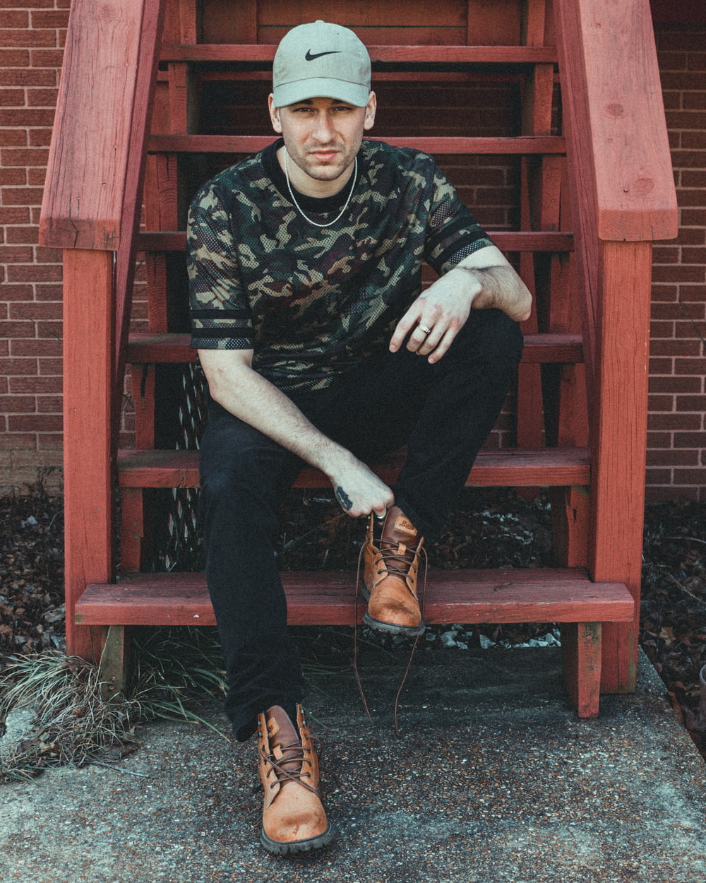 man sitting on brown wooden stairs