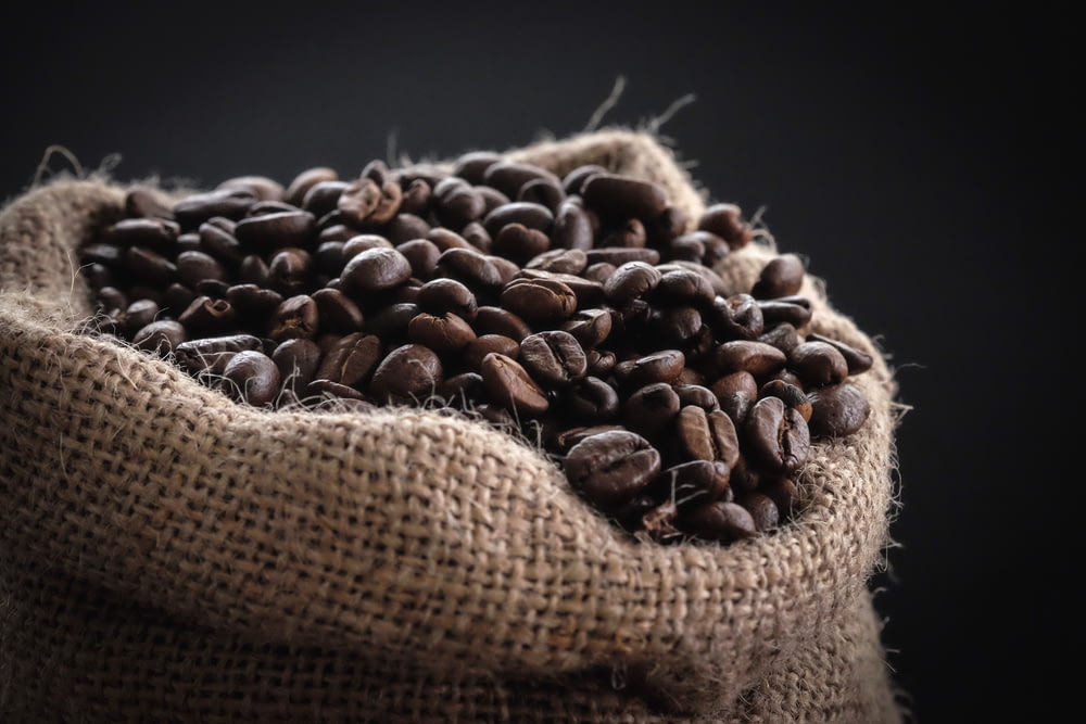 Photographie à mise au point peu profonde de grains de café dans un sac
