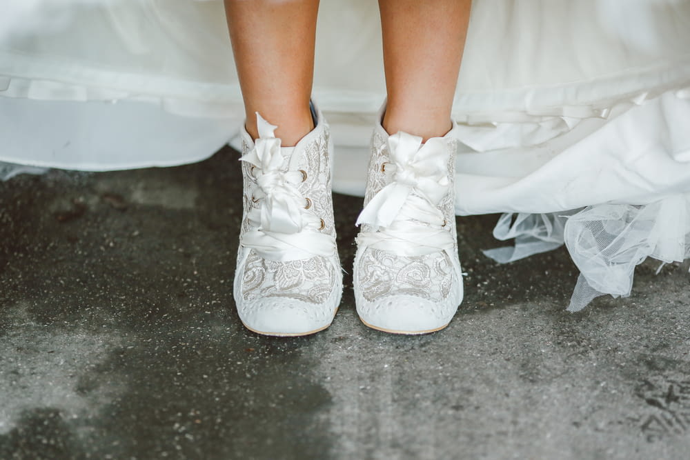 a close up of a person wearing white shoes